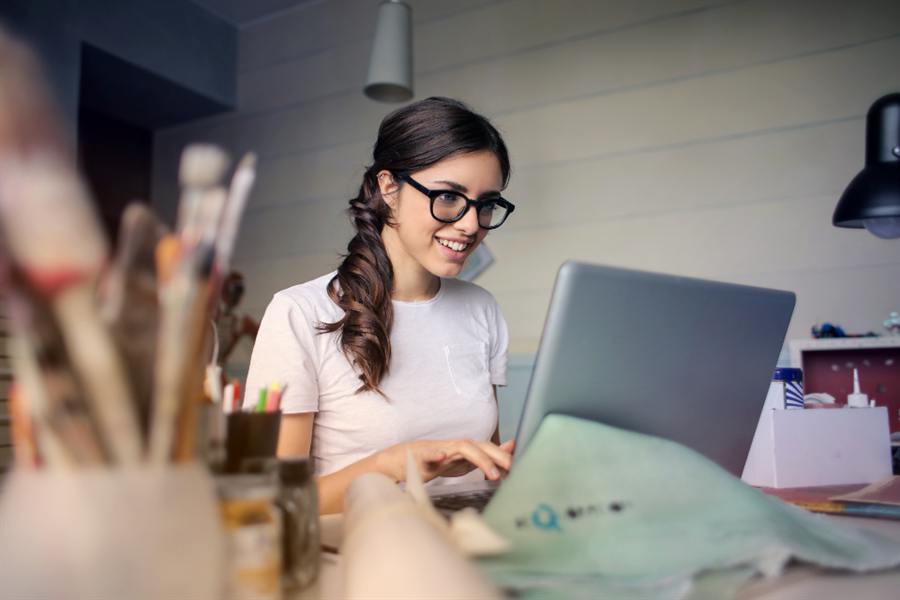 Someone smiling while working at a laptop